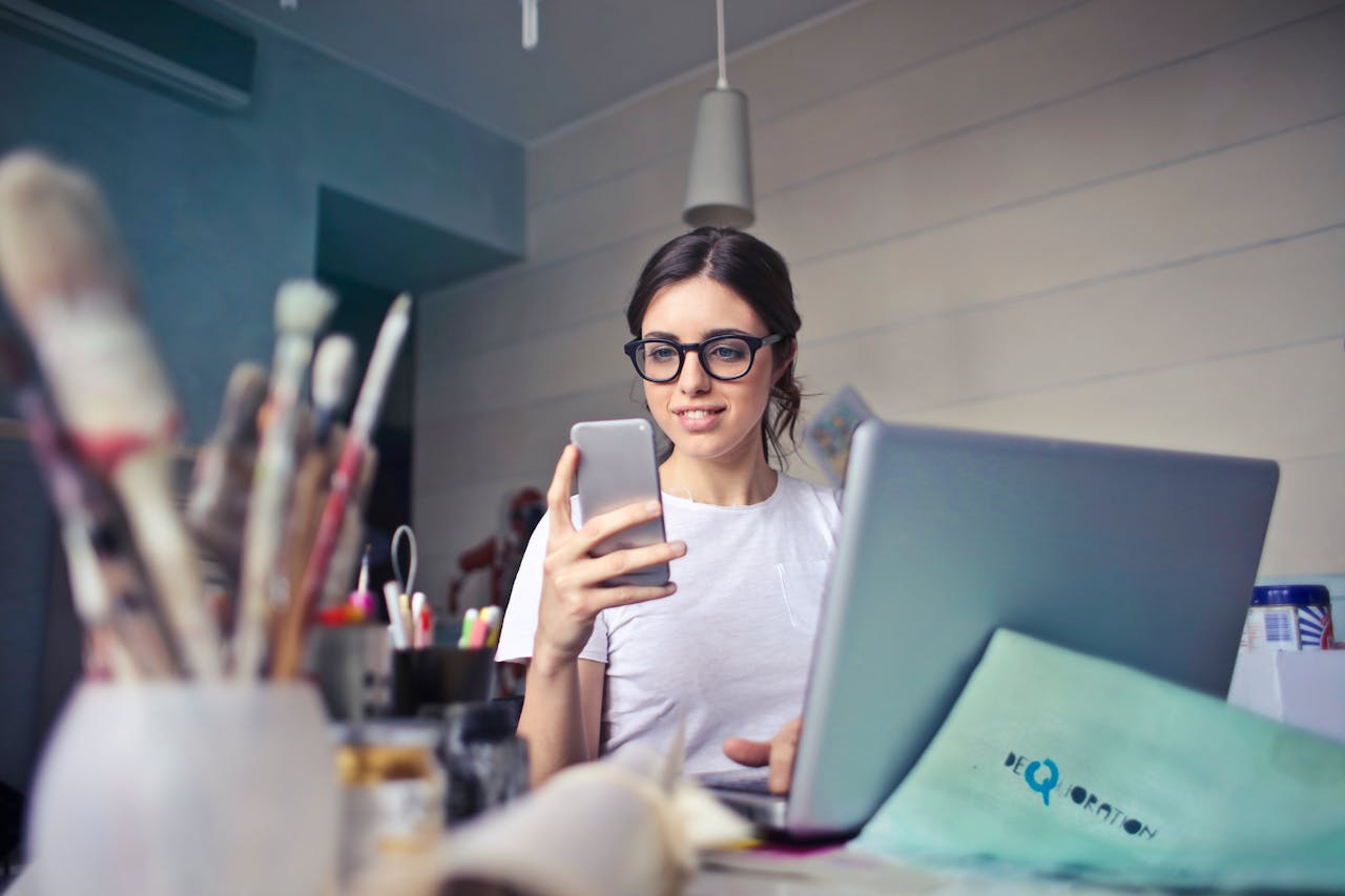 A therapist reviewing notifications on a laptop in a calm workspace.